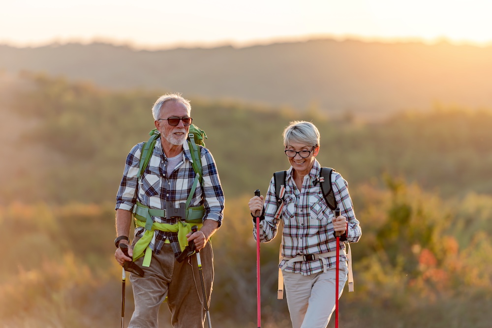 A happy older couple enjoying a hike outdoors near the senior living in Elkhorn